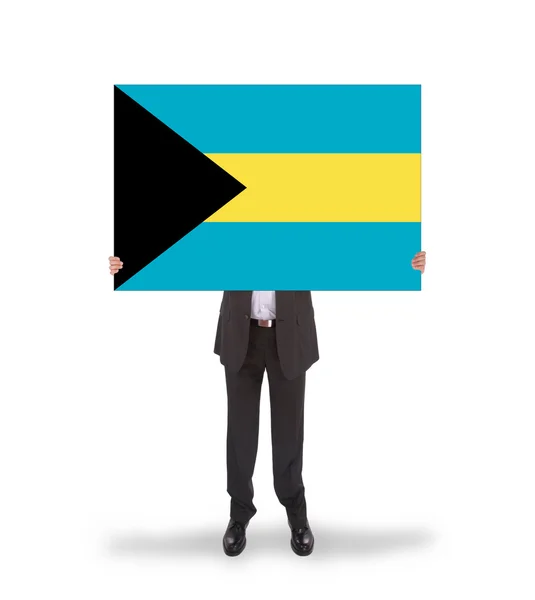 Empresario sosteniendo una gran tarjeta, bandera de las Bahamas —  Fotos de Stock