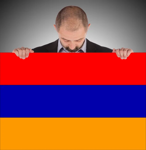 Empresario sosteniendo una tarjeta grande, bandera de Armenia —  Fotos de Stock