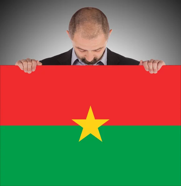 Empresario sosteniendo una gran tarjeta, bandera de Burkina Faso —  Fotos de Stock