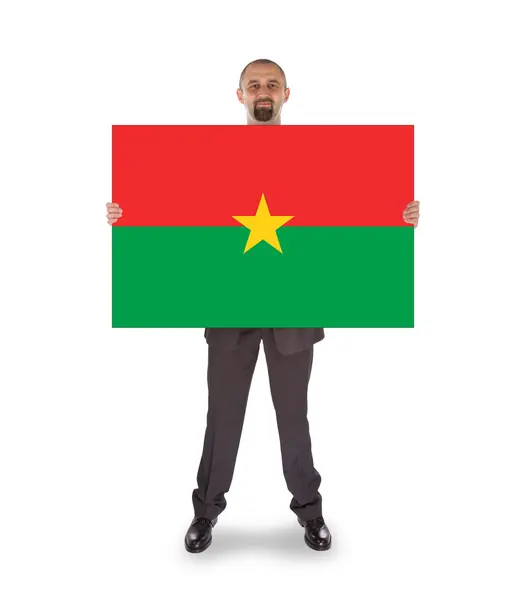 Empresário segurando um cartão grande, bandeira de Burkina Faso — Fotografia de Stock