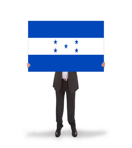 Empresario sosteniendo una tarjeta grande, bandera de Honduras —  Fotos de Stock