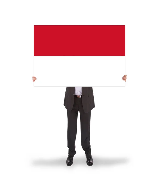 Empresario sosteniendo una tarjeta grande, bandera de Indonesia — Foto de Stock