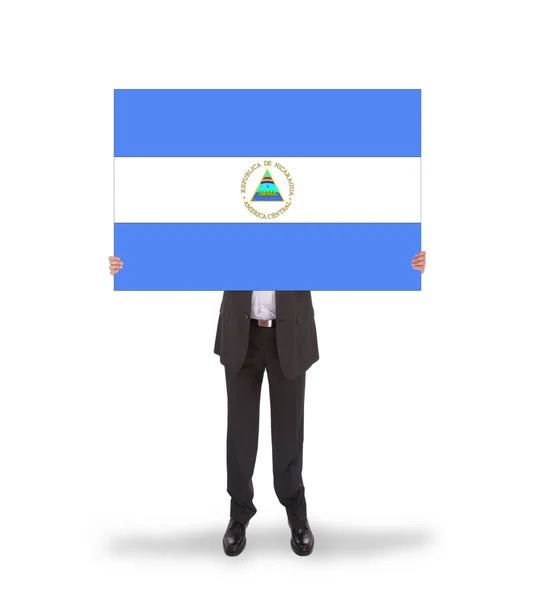 Empresario con una tarjeta grande, bandera de Nicaragua —  Fotos de Stock