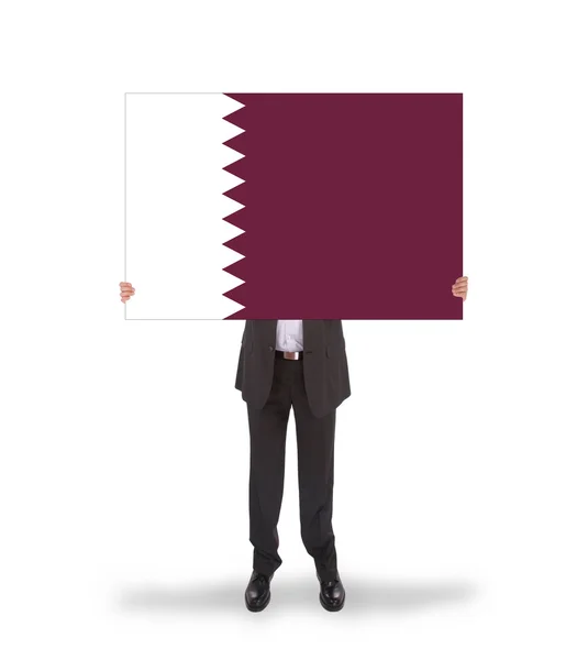 Empresario sosteniendo una gran tarjeta, bandera de Qatar — Foto de Stock