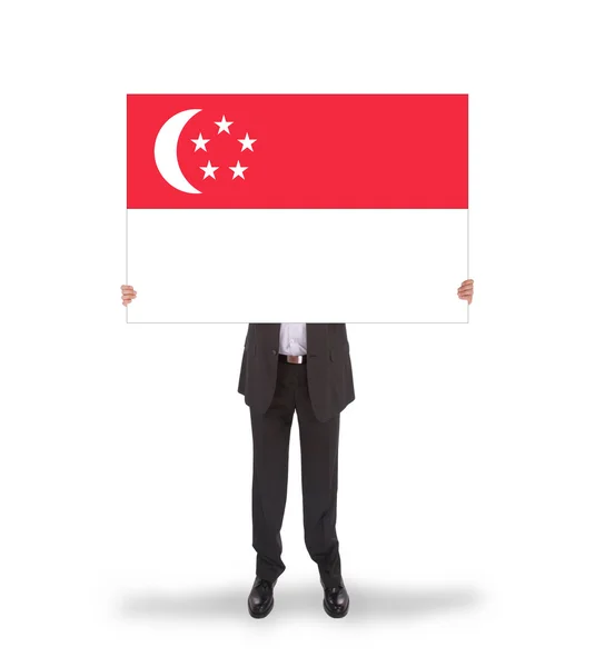 Businessman holding a big card, flag of Singapore — Stock Photo, Image