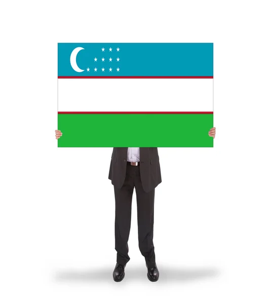 Businessman holding a big card, flag of Uzbekistan — Stock Photo, Image