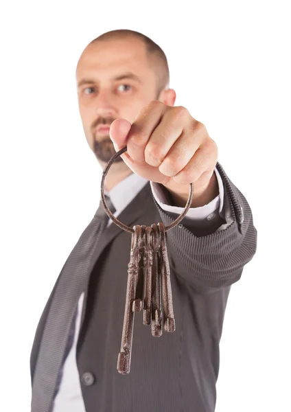 Человек в костюме дает старые ключи от дома — стоковое фото
