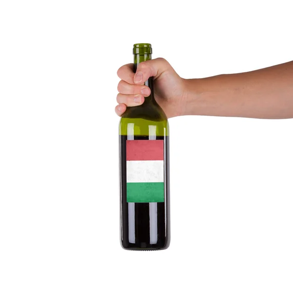 Mano sosteniendo una botella de vino tinto — Foto de Stock