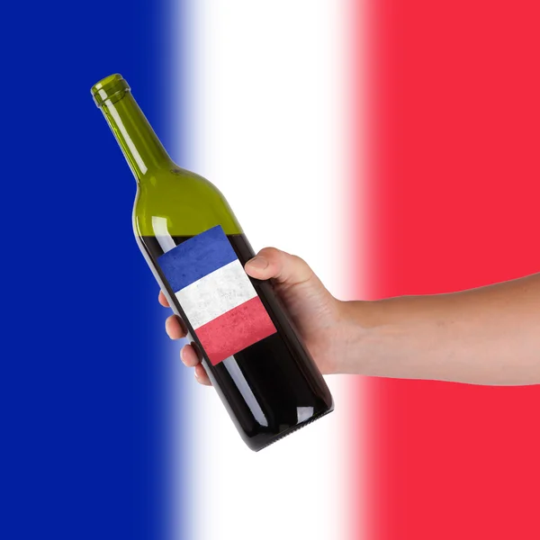 Hand holding a bottle of red wine — Stock Photo, Image