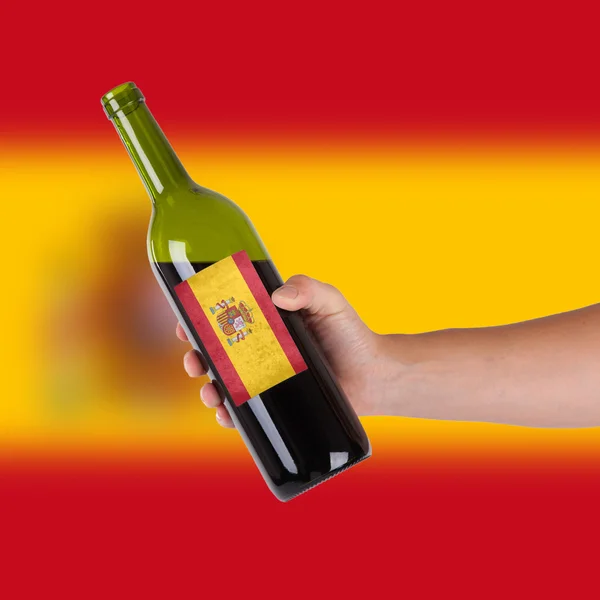 Hand holding a bottle of red wine — Stock Photo, Image