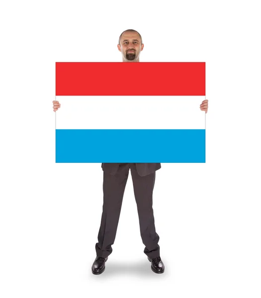 Smiling businessman holding a big card or flag — Stock Photo, Image