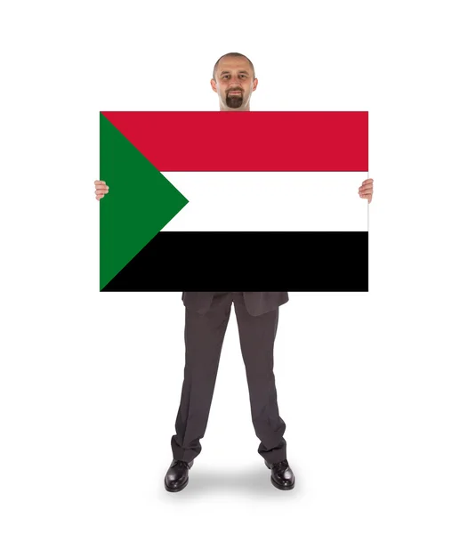 Smiling businessman holding a big card or flag — Stock Photo, Image