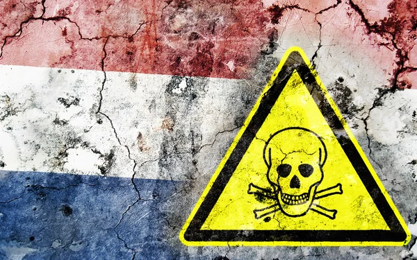 Old cracked wall with poison warning sign and painted flag — Stock Photo, Image