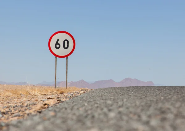 Señal de límite de velocidad en una carretera desierta en Namibia —  Fotos de Stock