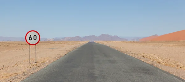 Señal de límite de velocidad en una carretera desierta en Namibia —  Fotos de Stock