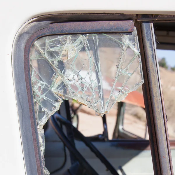 Velho carro sujo com janela quebrada — Fotografia de Stock