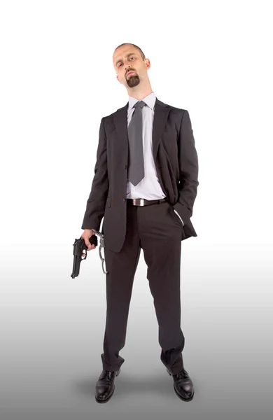 Businessman in handcuffs with pistol in hand — Stock Photo, Image