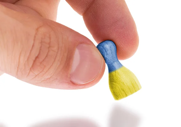 Hand holding wooden pawn, flag painting, selective focus — Stock Photo, Image