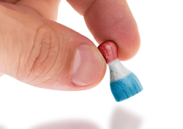 Peón de madera con una pintura de una bandera — Foto de Stock