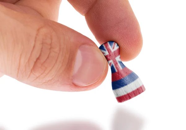 Hand holding wooden pawn, flag painting, selective focus — Stock Photo, Image