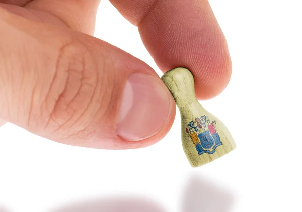 Hand holding wooden pawn, flag painting, selective focus — Stock Photo, Image