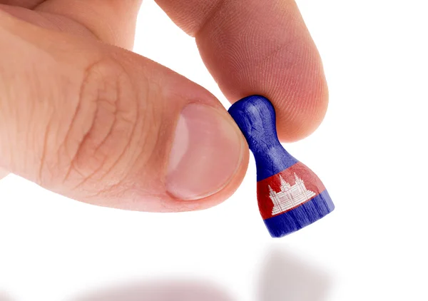 Hand holding wooden pawn, flag painting, selective focus — Stock Photo, Image