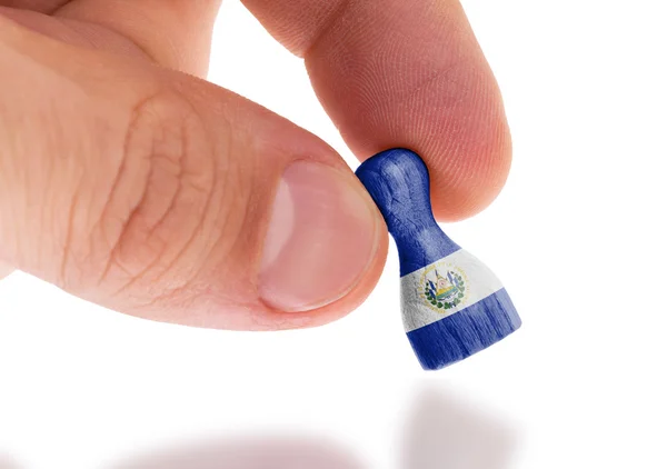 Hand holding wooden pawn, flag painting, selective focus — Stock Photo, Image