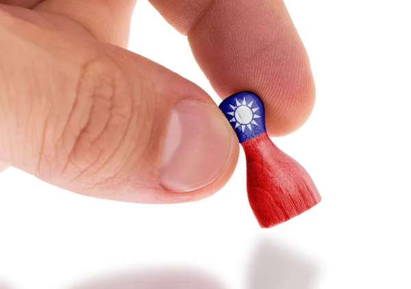 Mano sosteniendo peón de madera, pintura de bandera, enfoque selectivo —  Fotos de Stock