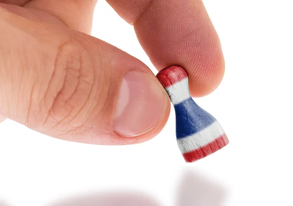 Mano sosteniendo peón de madera, pintura de bandera, enfoque selectivo —  Fotos de Stock