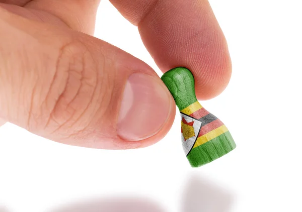 Hand holding wooden pawn, flag painting, selective focus — Stock Photo, Image