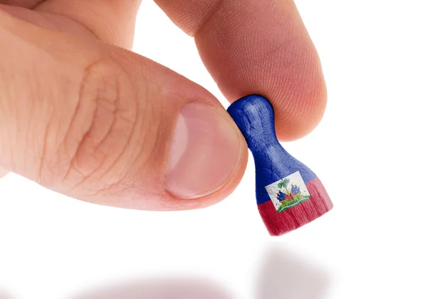 Hand holding wooden pawn, flag painting, selective focus — Stock Photo, Image