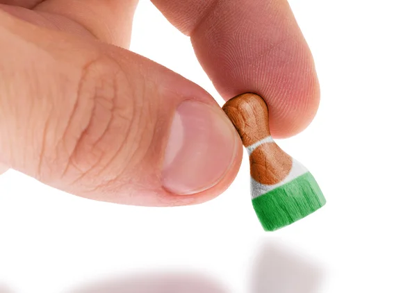 Mano sosteniendo peón de madera, pintura de bandera, enfoque selectivo —  Fotos de Stock