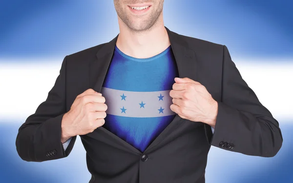 Businessman opening suit to reveal shirt with flag — Stock Photo, Image