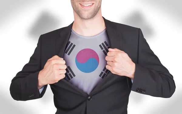 Businessman opening suit to reveal shirt with flag — Stock Photo, Image