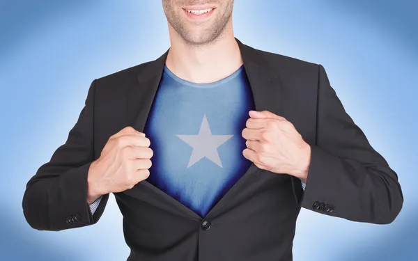 Hombre de negocios abriendo traje para revelar camisa con bandera — Foto de Stock