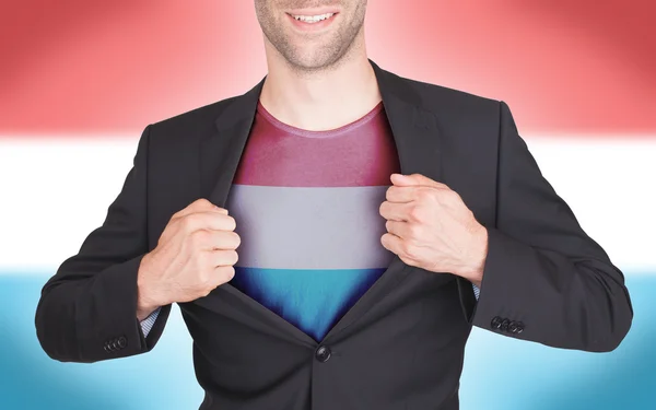 Businessman opening suit to reveal shirt with flag — Stock Photo, Image