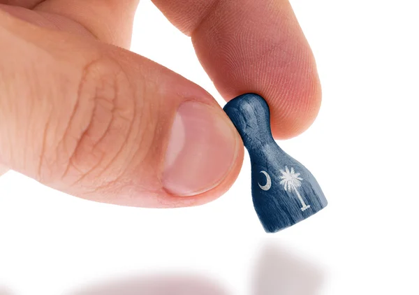 Hand holding wooden pawn, flag painting, selective focus — Stock Photo, Image