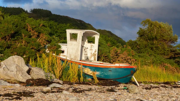 Loch taş plajı ile küçük gemi enkazı — Stok fotoğraf