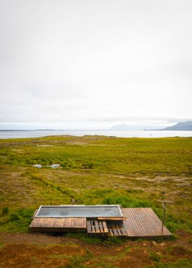 Hot tub at Djpivogur, hard to find but open for public, Getting warm in Iceland clipart