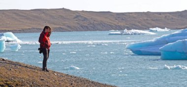 Jokulsarlon buzul lagün Güney İzlanda'vasıl belgili tanımlık kıyı üzerinde yürüyen kadın