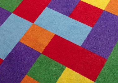 Yerde parlak renkli halı, kullanılmış ve biraz da kirli.