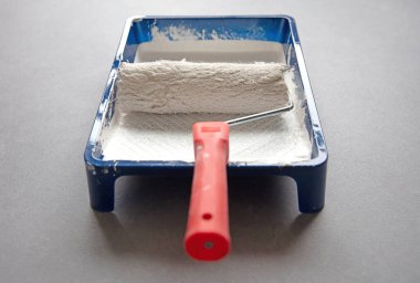 Kullanılmış ve temizlenmiş boya silindiri ve tava, seçici odak