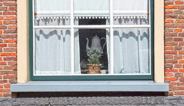 Window of cozy house with vintage curtains, the Netherlands of the past
