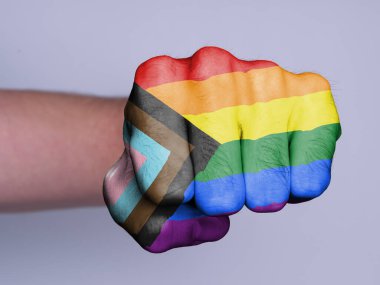 Beyaz zemin üzerinde yalıtılmış erkek yumruğu - İlerleme LGBTQ gökkuşağı bayrağı