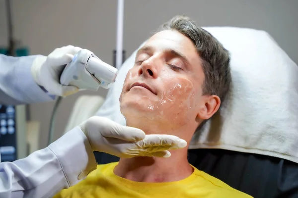 피부를 자극하기 치료를 잘생긴 잘생긴 남자의 얼굴을 봉합하는 — 스톡 사진