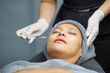 Yakından Asyalı güzeller güzellik kliniklerindeki kozmetologlardan yüz serumları alırlar. Güzellik ten konsepti.