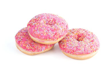 Beyaz arka planda küçük şekerli üç pembe çörek.