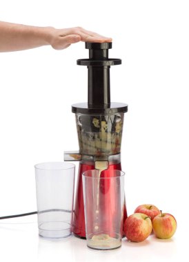 Meyve sıkacağı bembeyaz arka planda meyve suyu yapıyor.