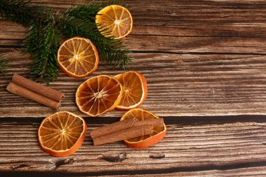 Noel için kurutulmuş portakal dilimleri ve tarçınlı ahşap masa.