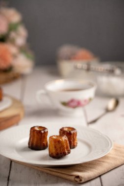 Bordeaux kanelleri bir tabakta ve beyaz ahşap bir masada çay